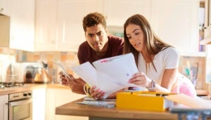 Couple inspecting documents at kitchen bench